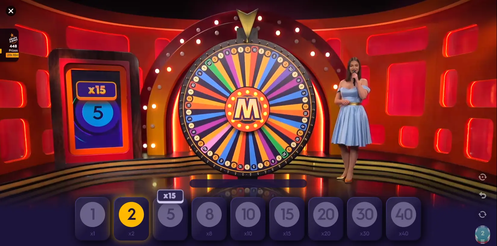 Mega Wheel studio interior view showcasing vibrant decor, central spinning wheel, players betting interface and lively host motivating participants